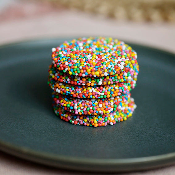 120g pack of milk chocolate discs covered in hundreds and thousands, made in Melbourne, Australia