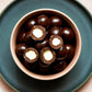 130g bag of vegan dark chocolate coated macadamias, made in Melbourne, Australia